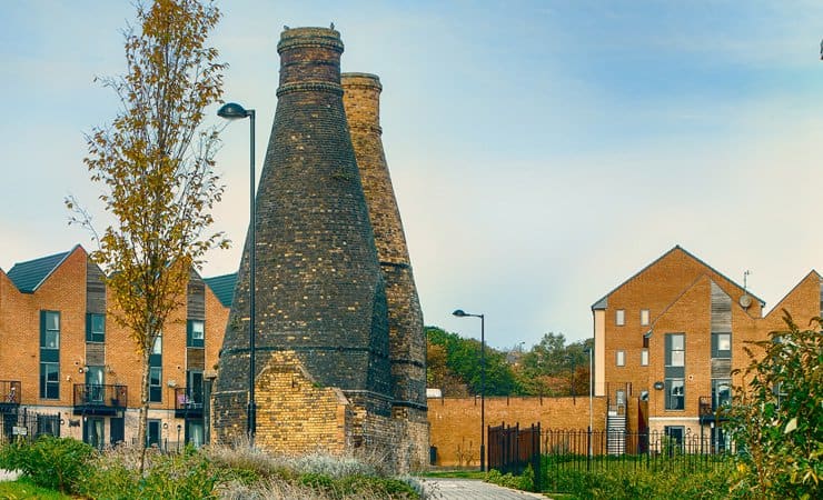 Two industrial bottle kilns within a modern housing estate in Stoke-on-Trent