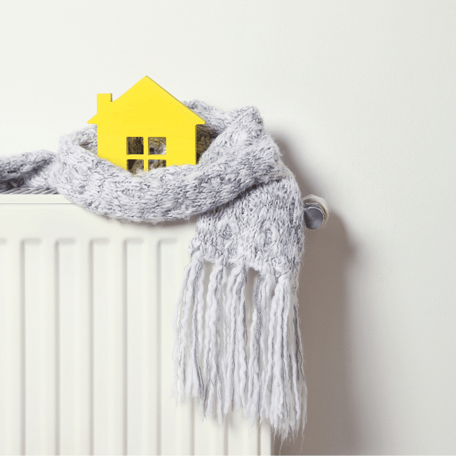 a model of a home wrapped in a scarf on a radiator