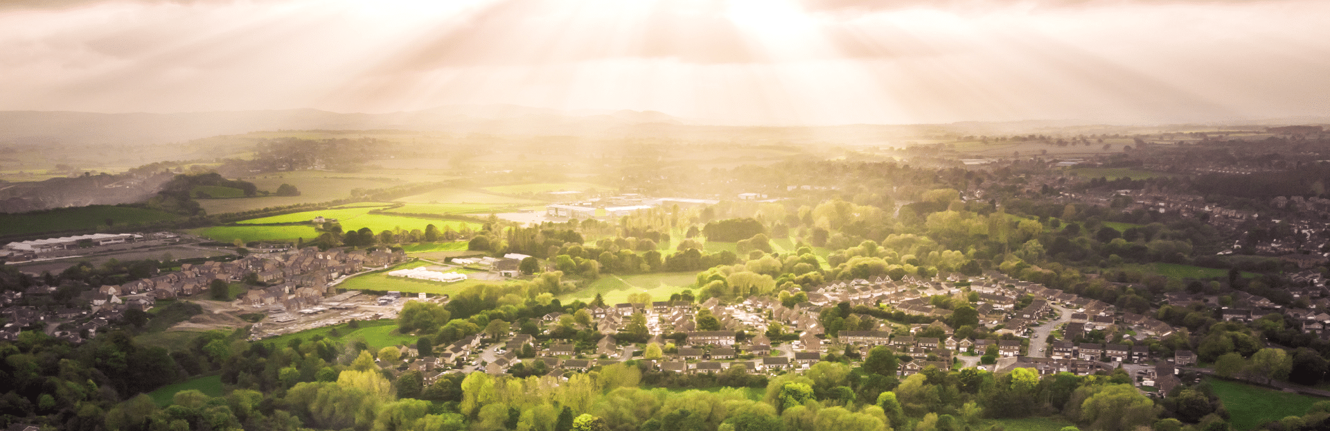 Aerial view of a UK town and green countryside at golden hour